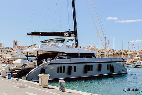 Eine große weiß-graue Yacht liegt im Hafen.