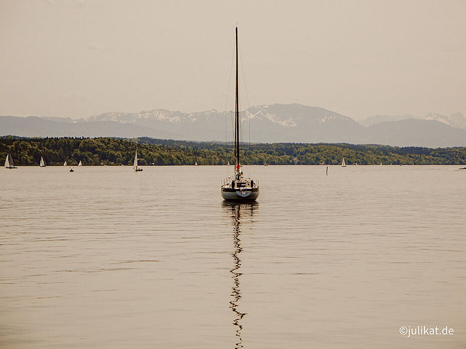 Einsames Segelboot auf dem Starnberger See vor Alpenkulisse