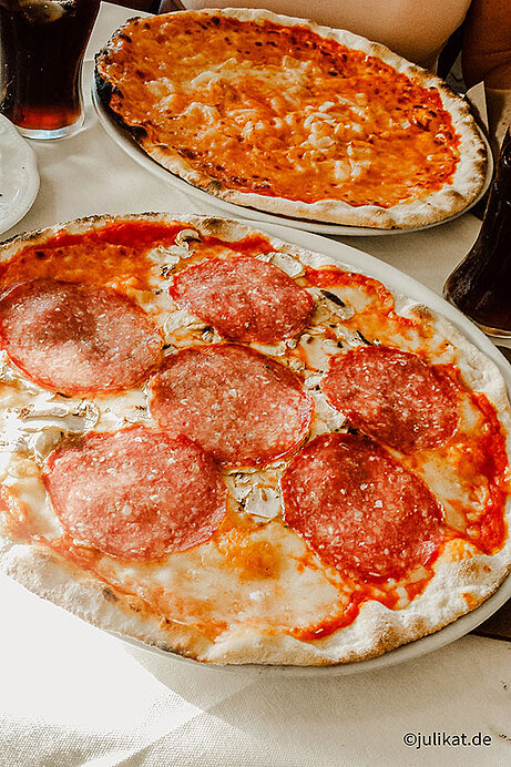 Zwei riesige Pizzen mit Salami