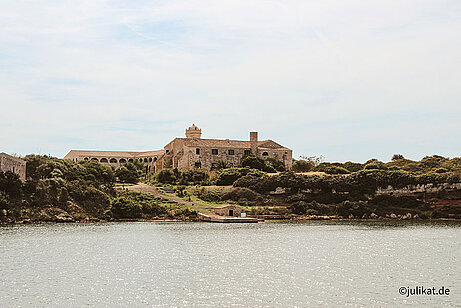 Blick zur Quarantäneinsel mit Steingebäude auf begrünter Insel.