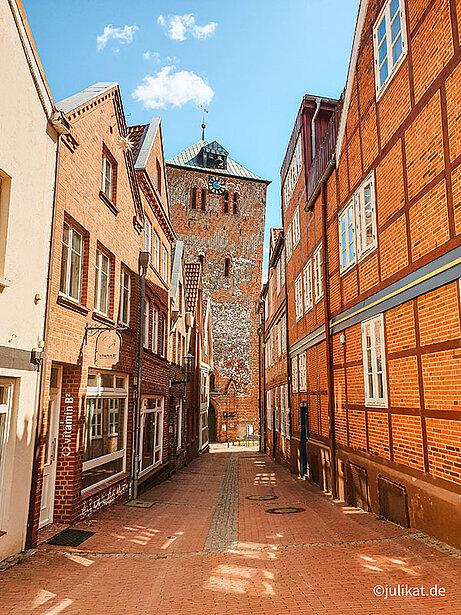 Schiefer Kirchturm am Ende der Fachwerkgasse