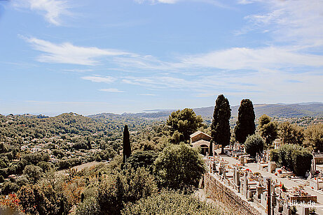 Das Panorama ragt über den Friedhof und die Berge bis hin zum Meer am Horizont.