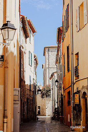 Eine sonnengelbe, mediterrane Gasse verbirgt sich hinter dem Eingangstor.